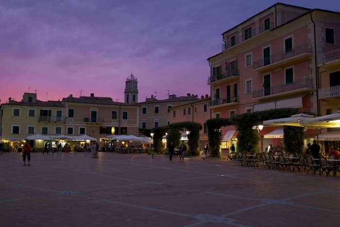 Town square at dusk with buildings and outdoor seating
