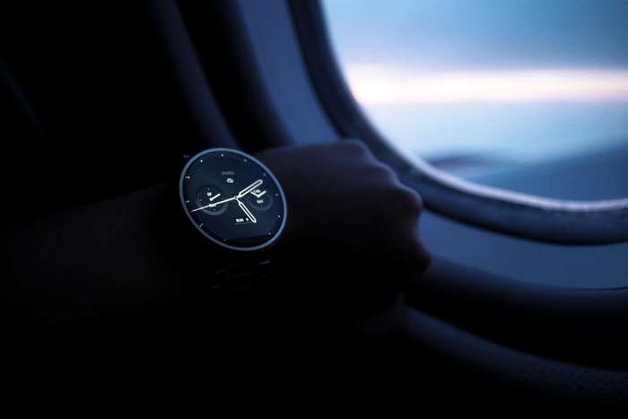 Motorola Moto 360 smartwatch on wrist by airplane window