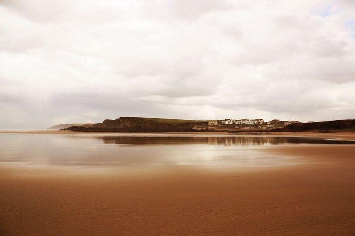 Coastal town on a cliff overlooking a sandy beach and ocean