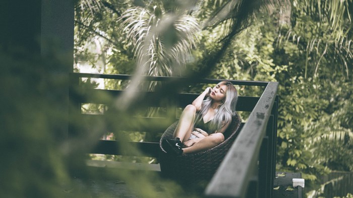 Woman relaxing on a balcony surrounded by nature