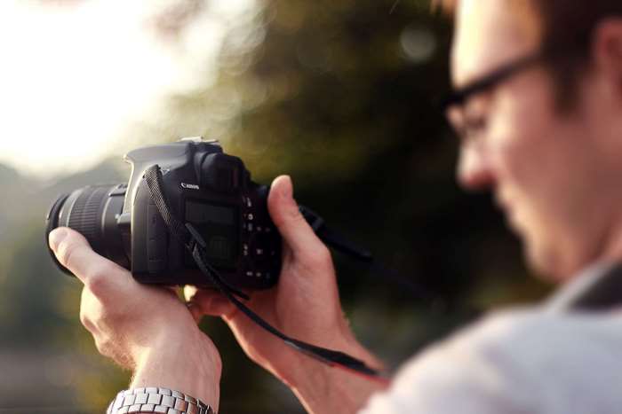 Man holding a Canon DSLR camera