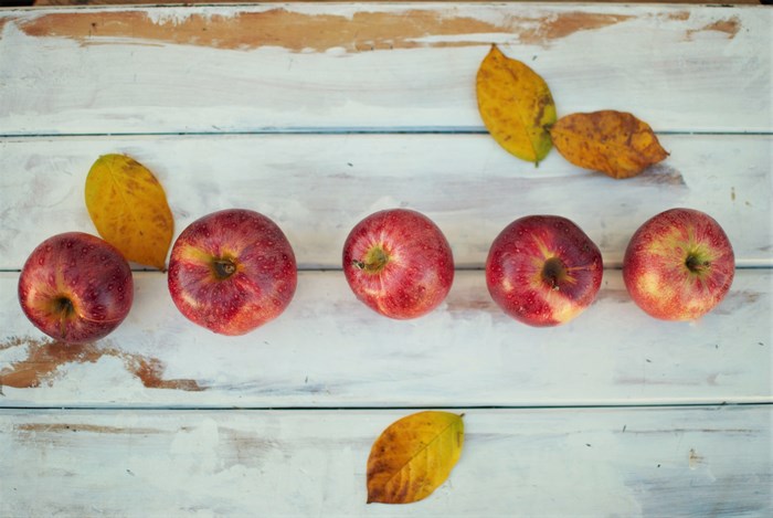 Apples and autumn leaves on a wooden table