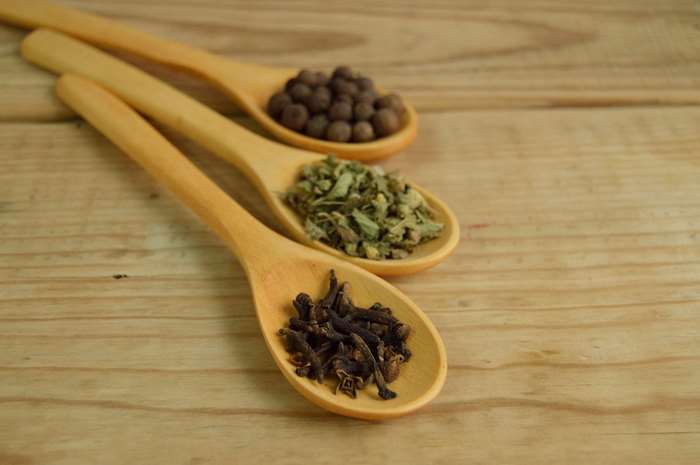 Wooden spoons with spices on a wooden table