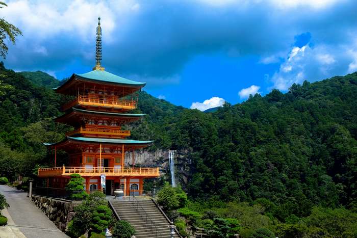 Orange pagoda with waterfall in a forest landscape