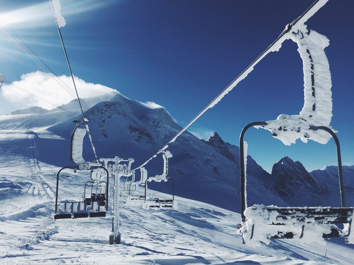 Ski lift covered in snow on a sunny winter day