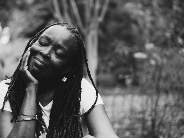Black woman with dreadlocks smiling with eyes closed
