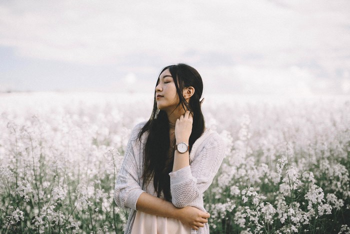 Young Asian woman in a field of white flowers