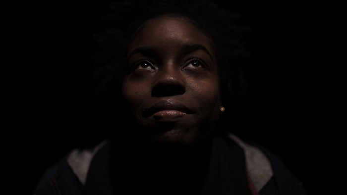 African American woman looking up in the dark