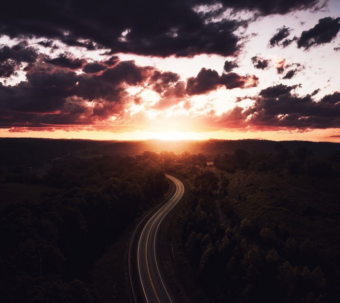 Highway curving through a forest at sunset in Ohio