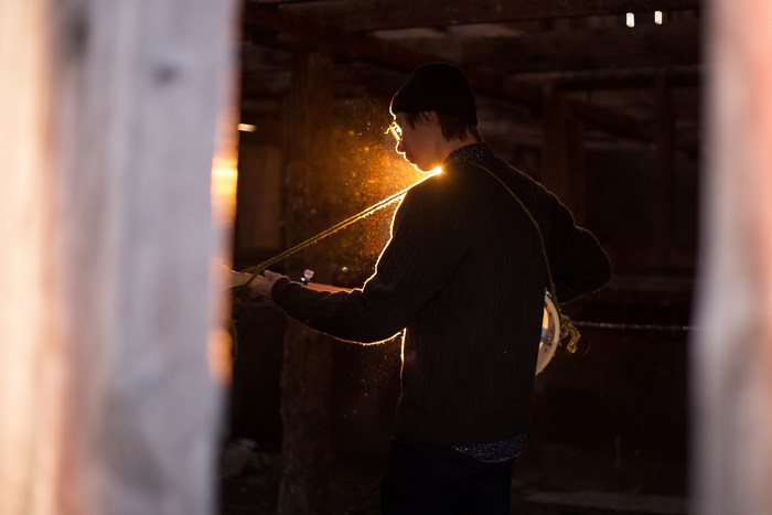 Man playing a musical instrument in a barn