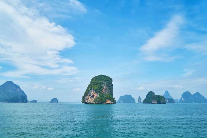 Limestone islands in the ocean under a blue sky
