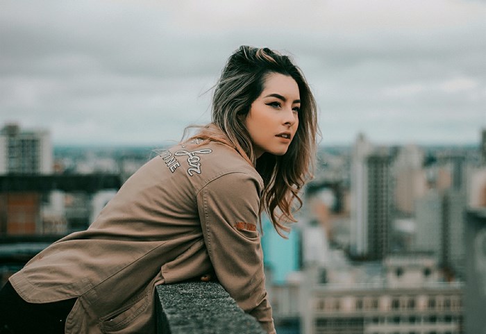 Woman leaning on a wall overlooking a city