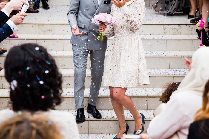 Joyful Wedding Couple Walking Down Steps with Confetti