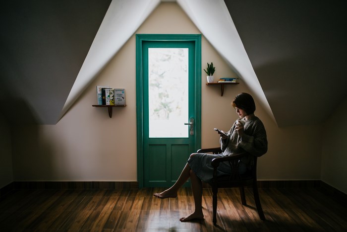 Woman sitting in a room with a green door