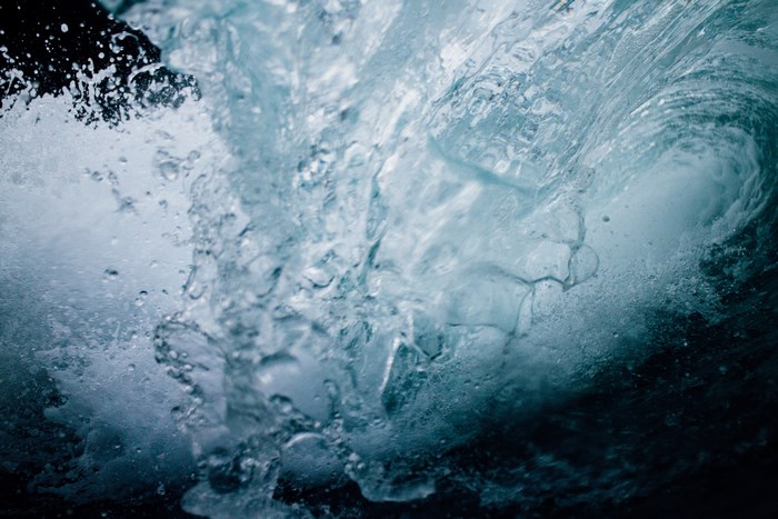 Underwater view of a crashing ocean wave with foam and bubbles