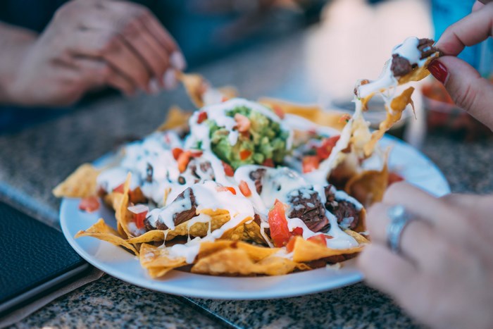 Plate of loaded nachos with guacamole and cheese