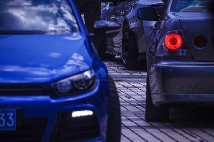Blue car and other vehicles parked on a street