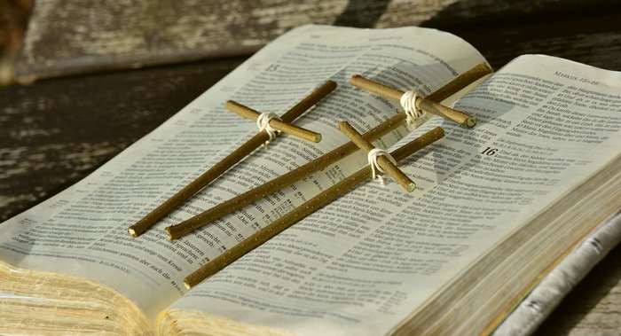 Three wooden crosses on an open Bible