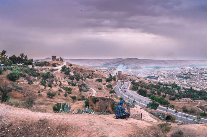 Man sitting on hill overlooking Fes, Morocco