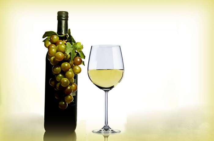 Bottle of white wine with grapes and a glass