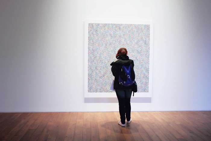 Woman viewing a large abstract painting in a gallery
