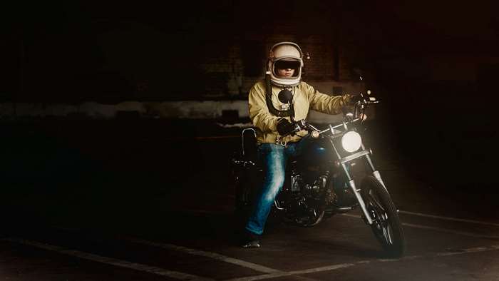 Man in helmet riding a motorcycle at night