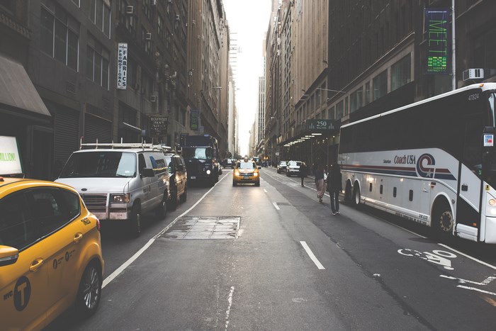 Coach USA bus and taxis on a busy city street