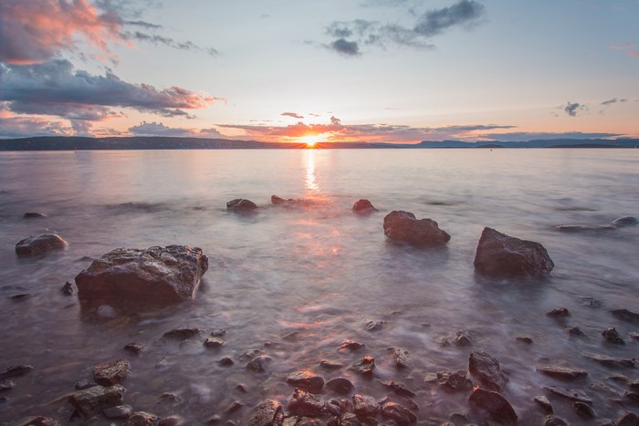 Sunset over a rocky lake shoreline