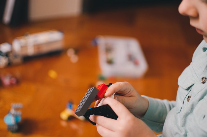 Boy playing with Lego bricks indoors
