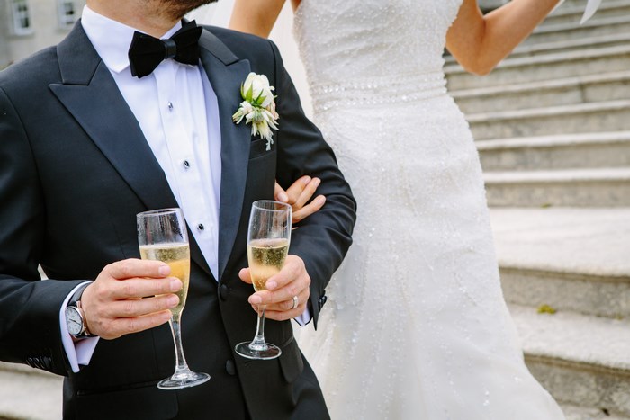 Groom and Bride Holding Champagne Flutes on Wedding Day