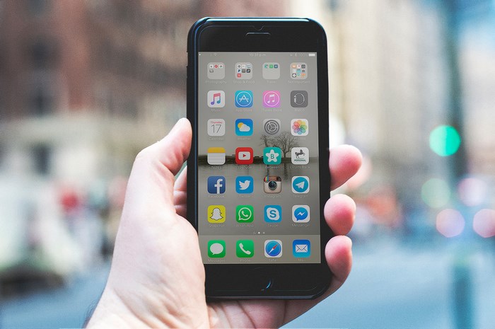 iPhone 6 mock up held in hand outdoors