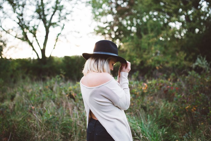 Woman in a hat in a grassy field