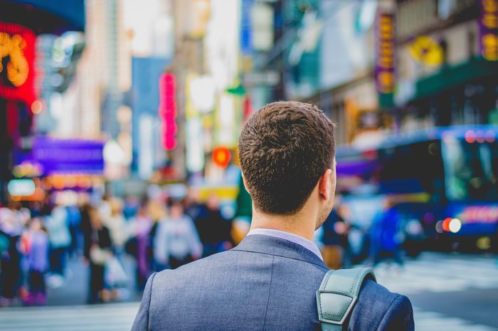 Man in suit in Times Square with backpack