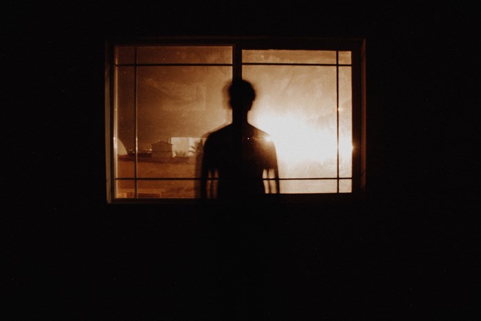 Silhouette of a person in a window at night
