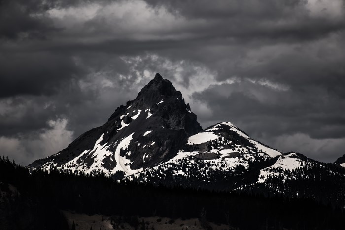 Dark Mountain Peak with Snow Under Overcast Sky