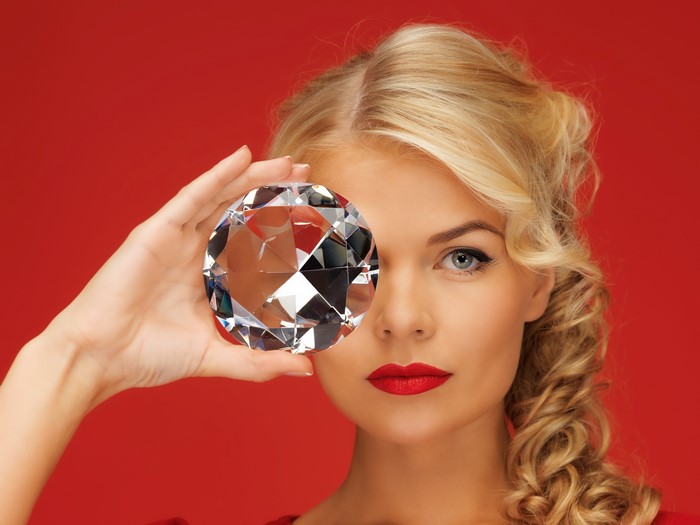 Blonde Woman Holding Large Diamond Red Background