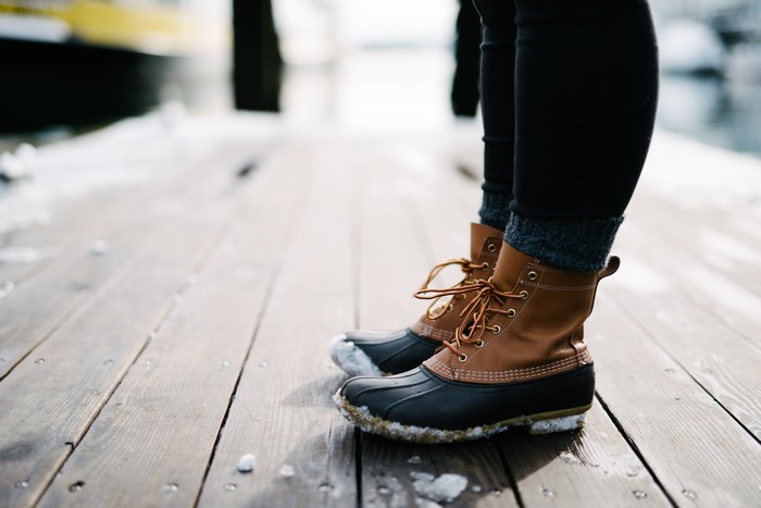 LL Bean boots on a snowy wooden dock