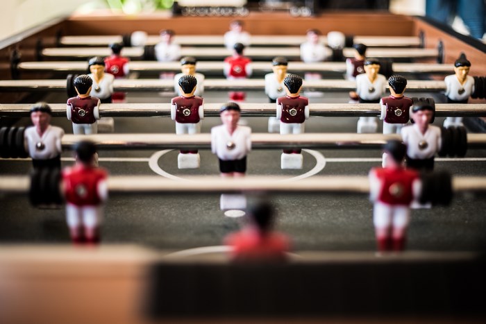 Close-up of a foosball table with blurred players