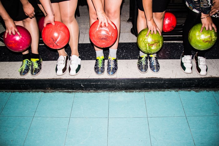 Group of people holding bowling balls