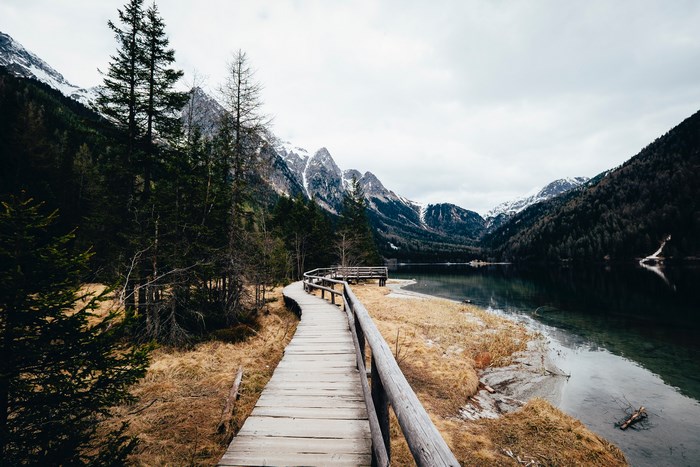 Wooden walkway along a lake with mountains
