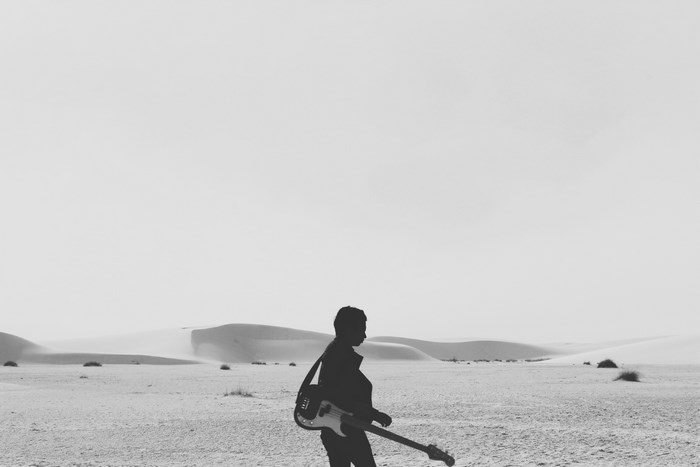 Silhouette of a man with a guitar in the desert