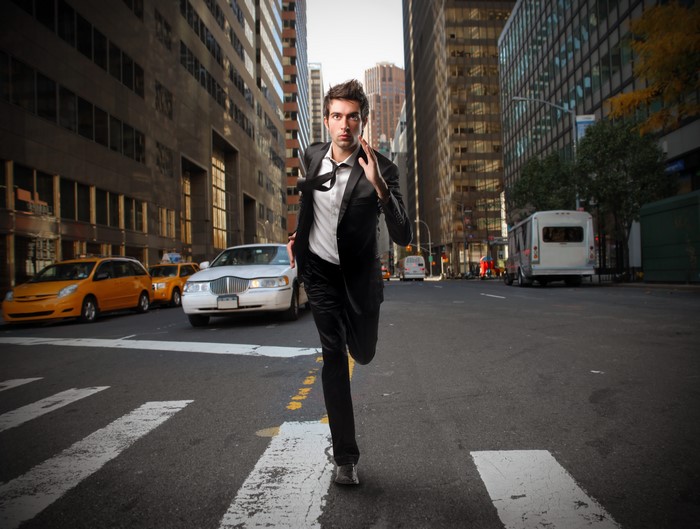 Man in Suit Running Across City Street