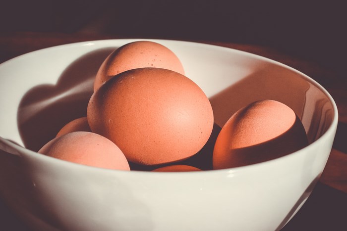 Brown eggs in a white bowl with shadows