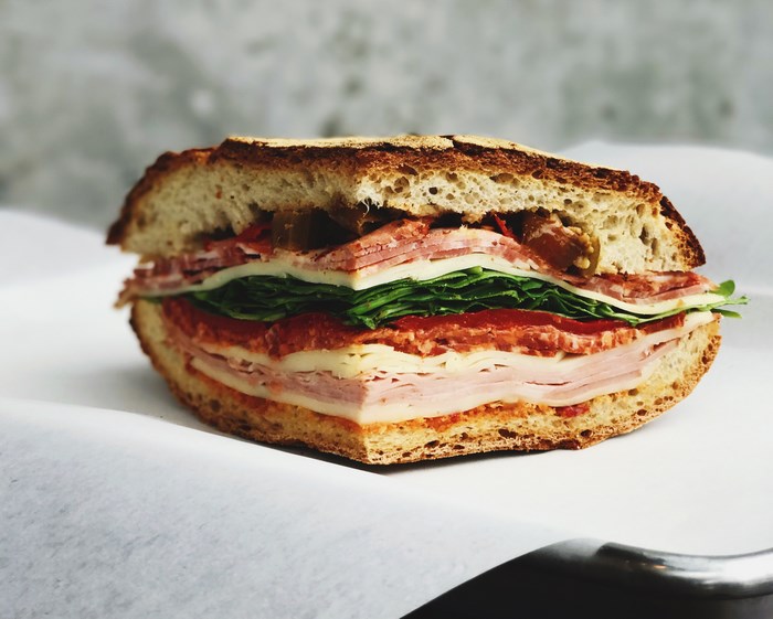 A large, layered sandwich on a white surface