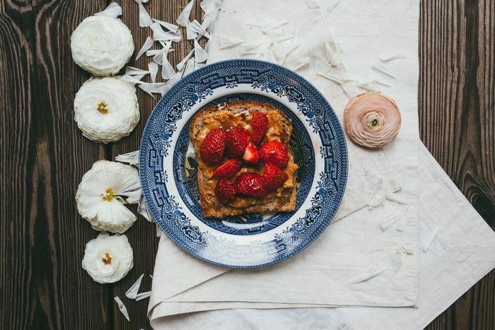 Toast with peanut butter and strawberries on a plate