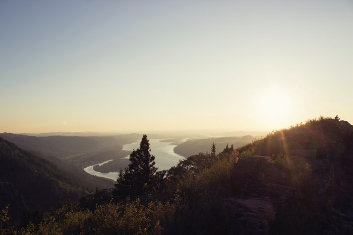 Sunset over a winding river valley with mountains