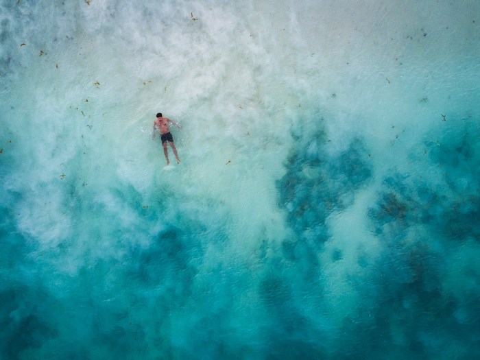 Man swimming in turquoise ocean water near Tulum