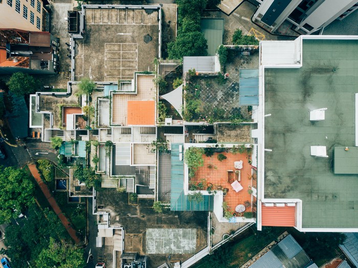 Aerial view of a complex urban rooftop with gardens and buildings