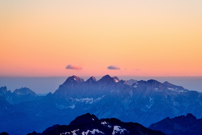 Mountain peaks at sunset with clouds