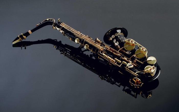 Black and gold saxophone on a reflective surface
